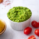 pesto in a bowl with cherry tomatoes
