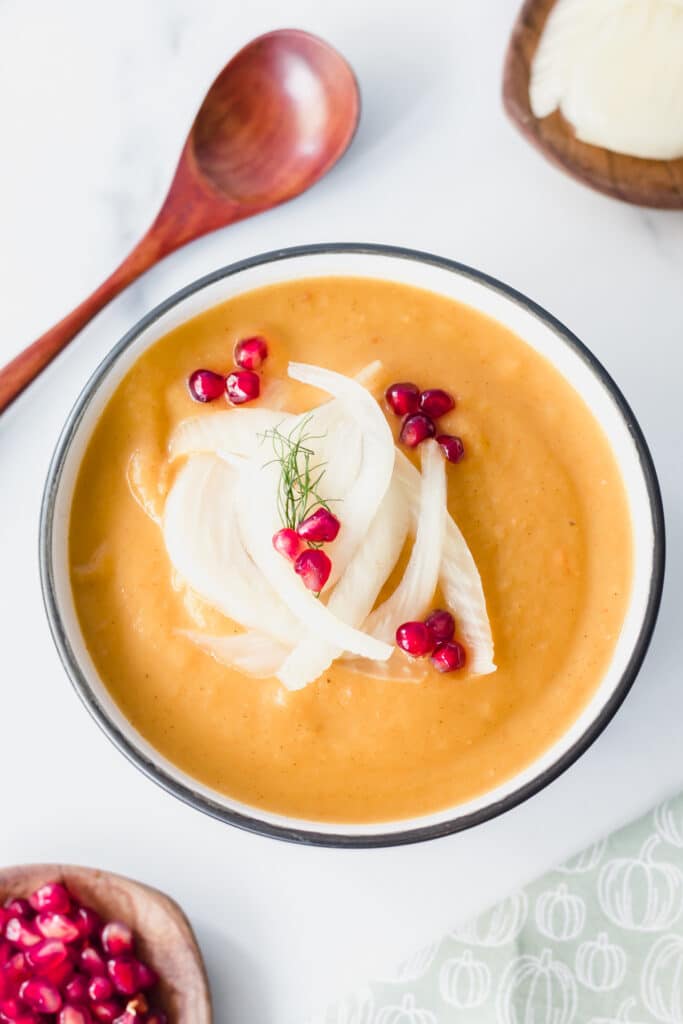 butternut squash soup with pomegranate seeds and fennel on top and in bowls