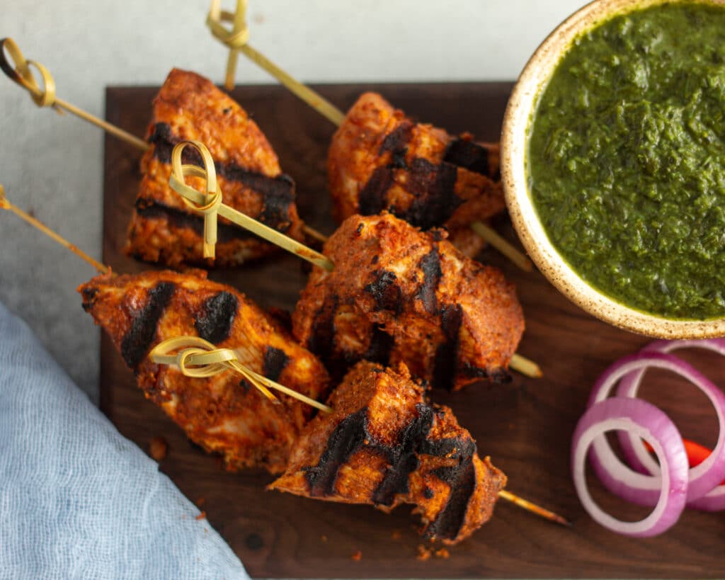 Skewered chicken tikka with mint chuntey in a bowl in the